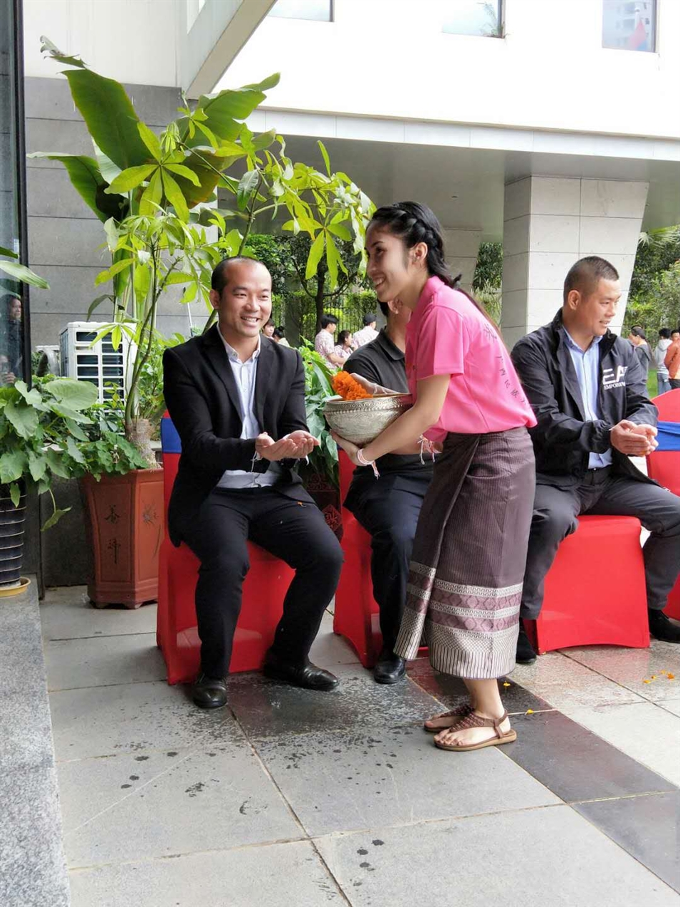 老撾駐廣西留學(xué)生代表將浸有花瓣的香水灑客人的手上，表示對嘉賓的美好祝福（圖一）