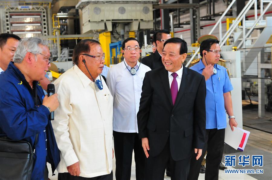 3月10日，在老撾沙灣拿吉省車邦縣，老撾人民革命黨中央總書記、國家主席本揚（左二）在山東太陽紙業(yè)股份有限公司董事長李洪信（右二）的陪同下視察公司。 新華社記者章建華攝
